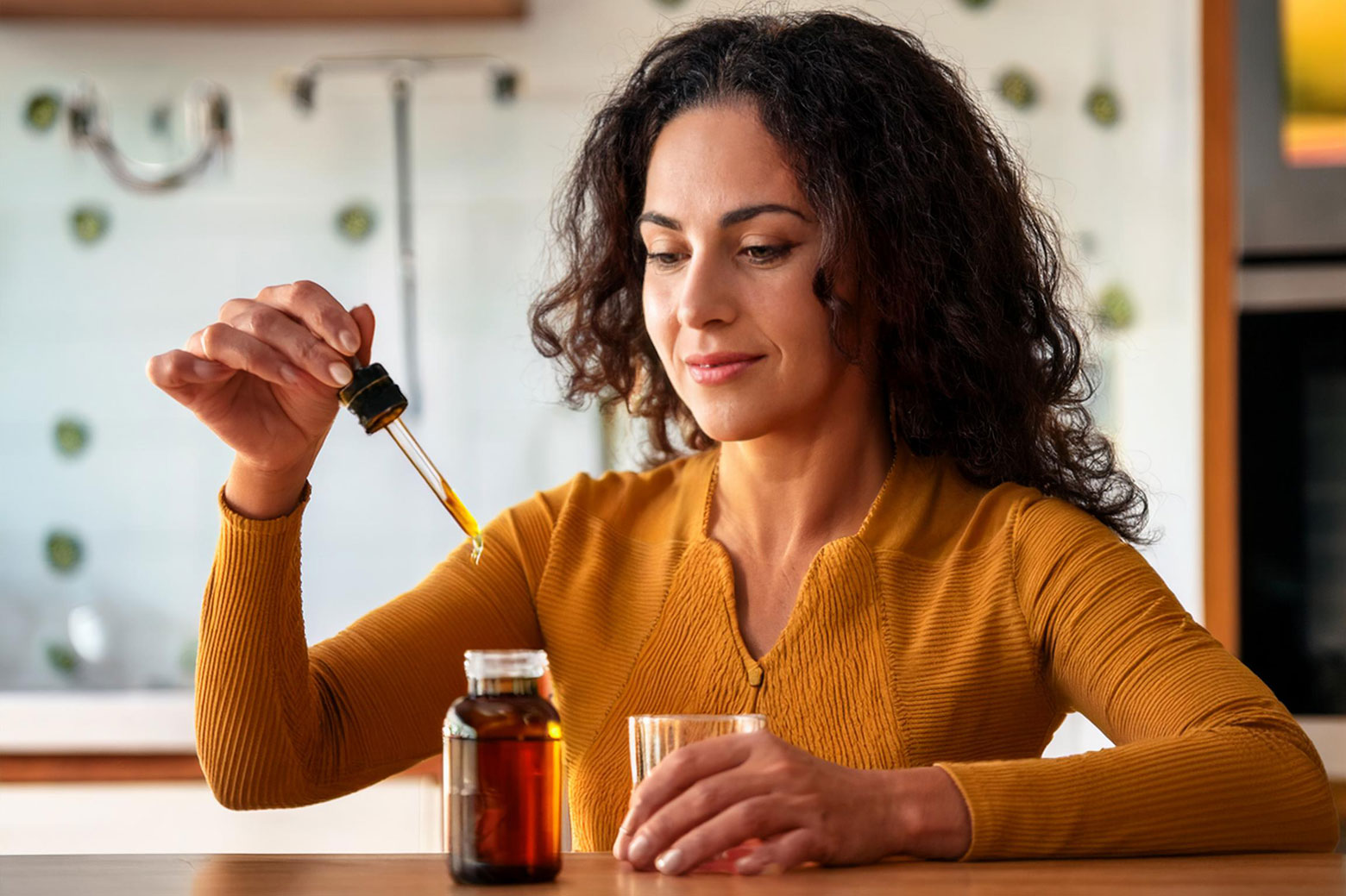 A woman adding parasite cleanse drops to her favorite drink.